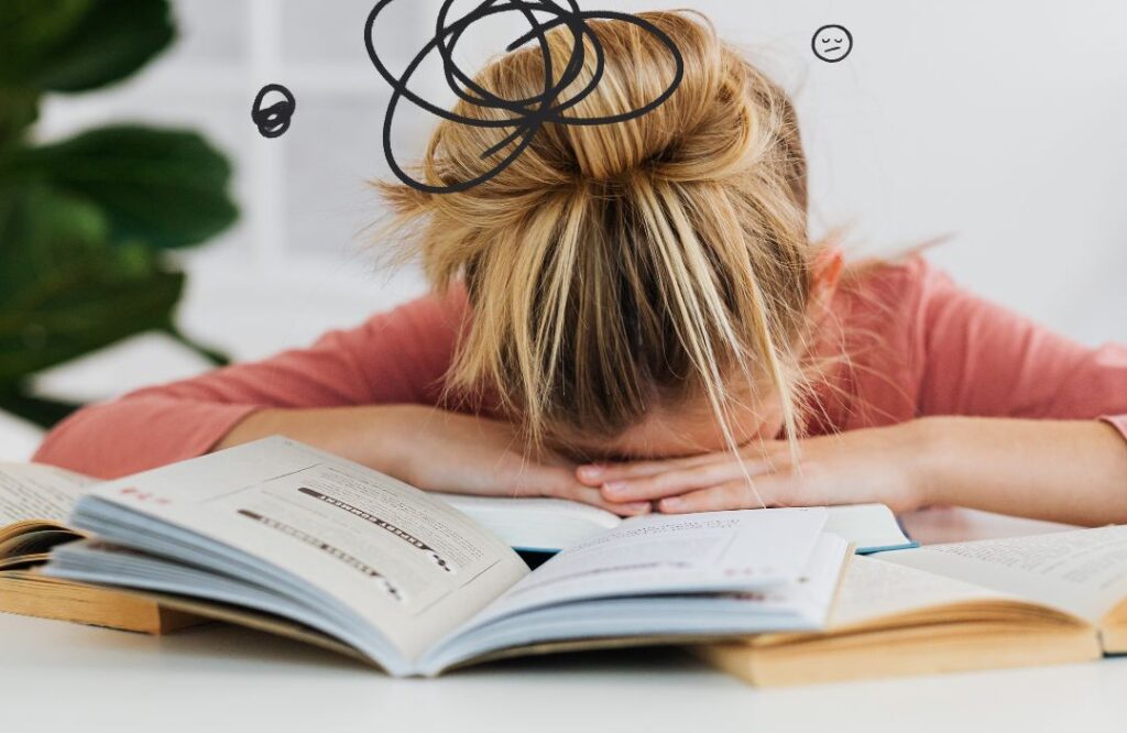 Ragazza stressata su libri con ansia prestazione.